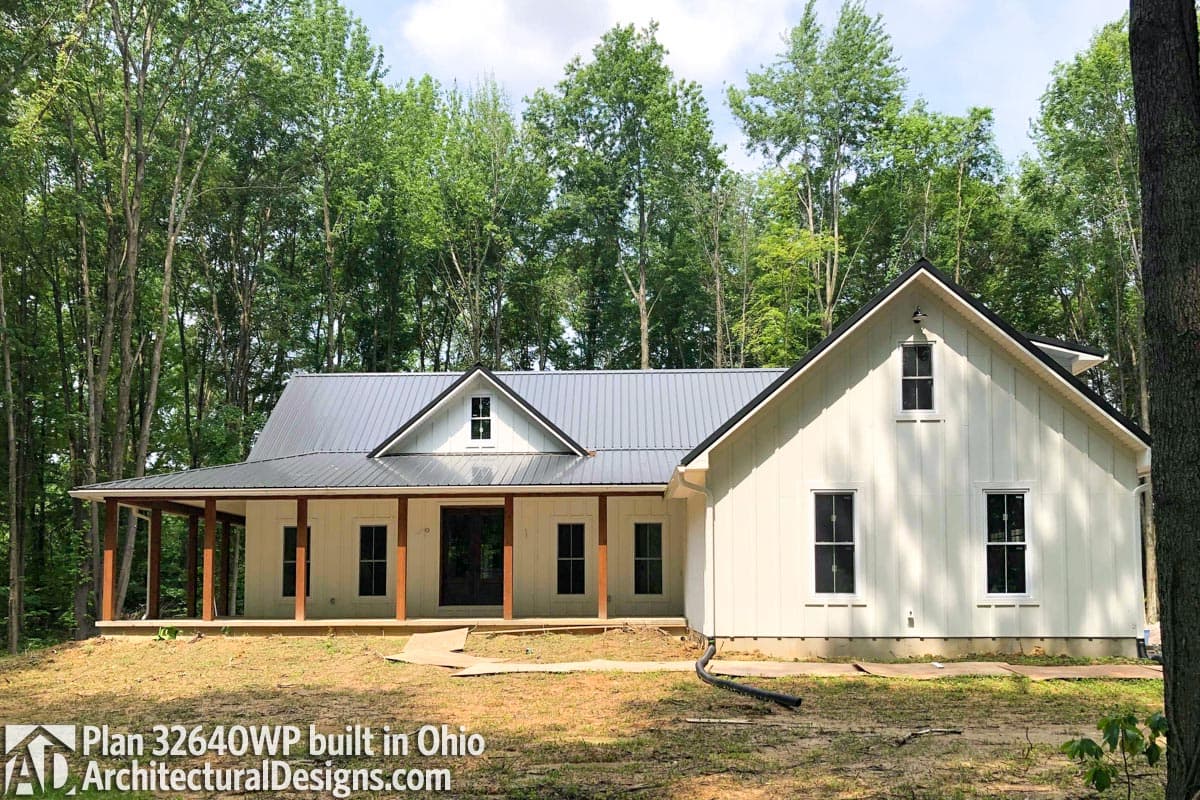 Modern farmhouse house plan exterior with a wrap-around porch, metal roof, and board and batten siding.