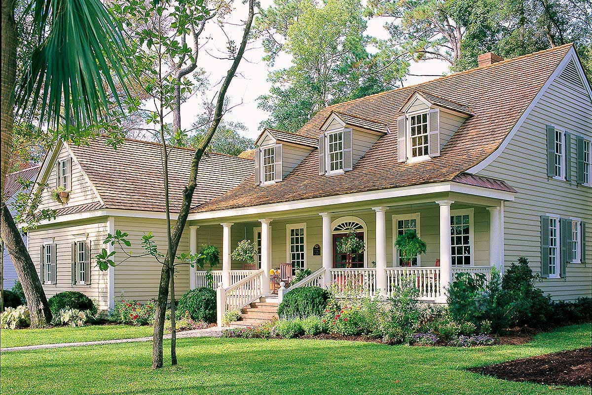 House plan exterior. Two-story Colonial with a porch, dormers, and a gabled roof. Columns support the porch roof.