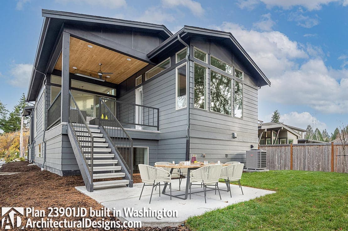 Modern house plan exterior with covered deck, large windows, and exterior staircase. Features horizontal siding.