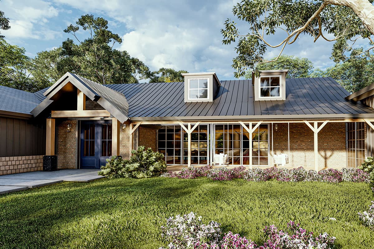 Modern farmhouse exterior with metal roof, gabled entry, exposed beams, and dormer windows.