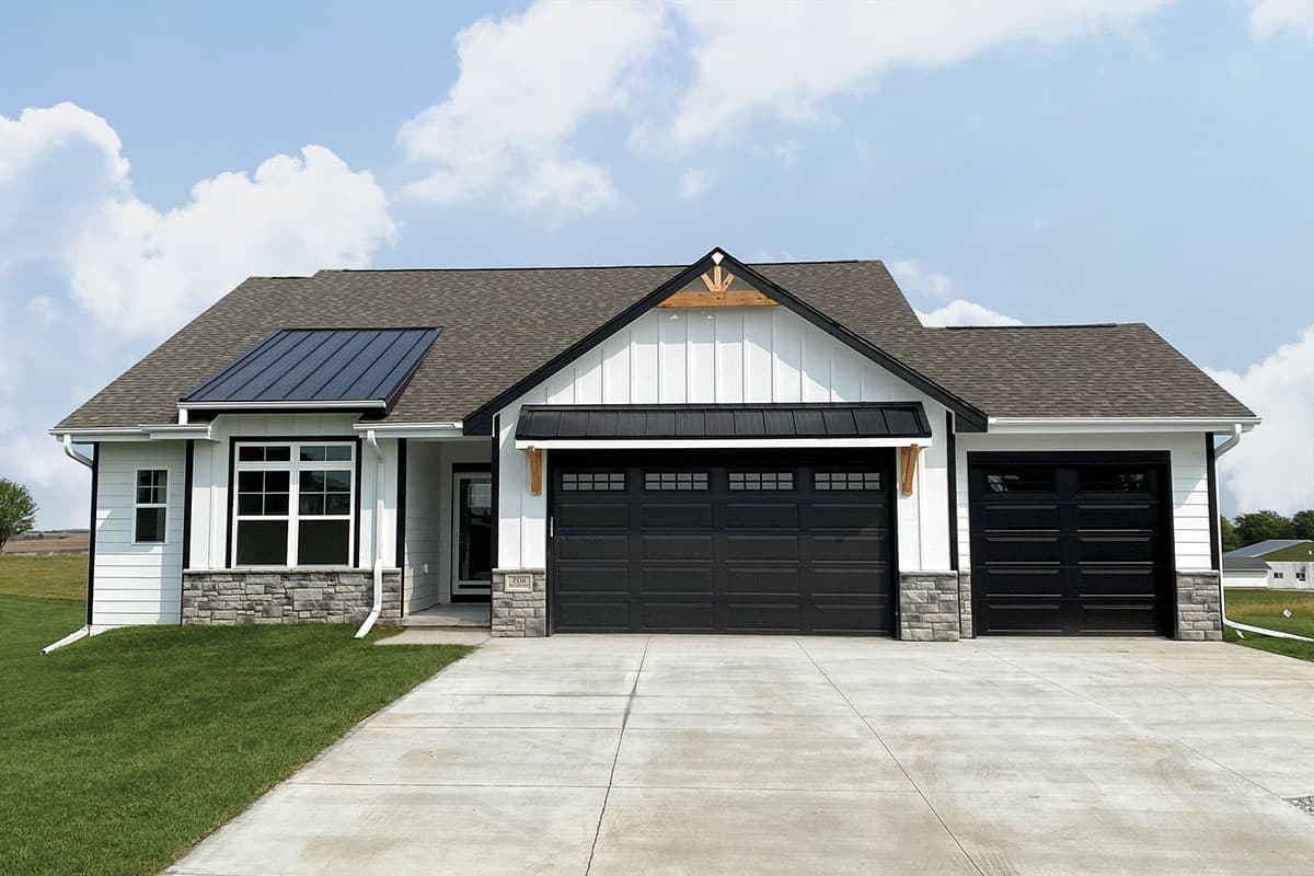 House plan exterior. Single-story Modern Farmhouse with a gabled roof, board and batten siding, and two garage bays.