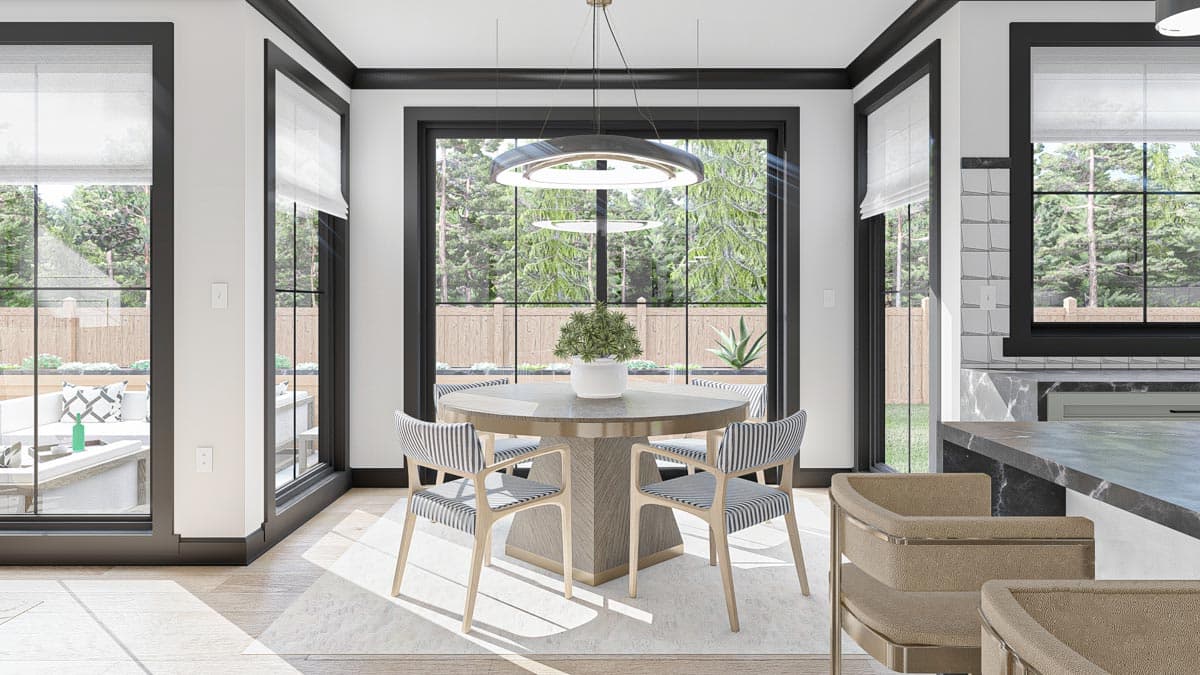 Dining area with round table, striped chairs, large windows, and view of backyard patio.