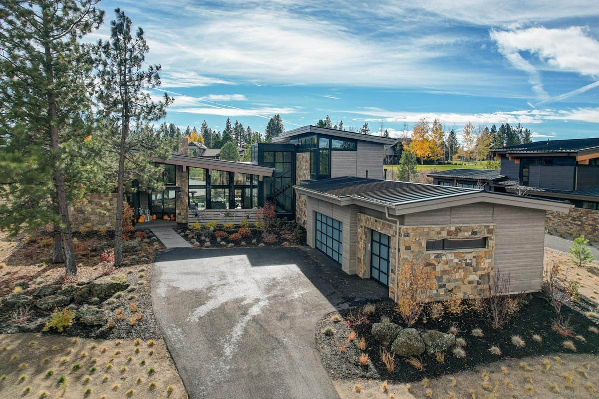 Modern house plan exterior with stone and wood siding, multiple gables, and attached garage.