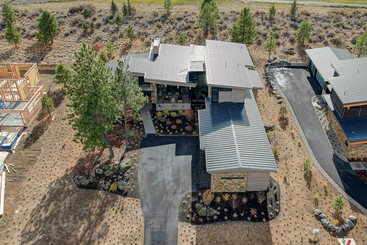 Modern house plan exterior with multiple gabled rooflines, stone accents, covered porch, and attached garage.