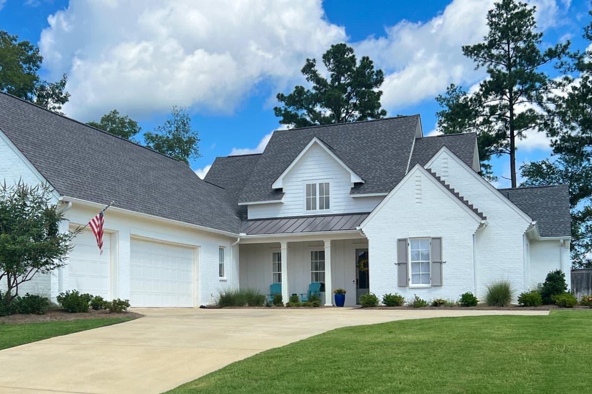 House plan exterior: Modern Farmhouse style, white brick, two-story, attached garage, covered front porch with columns.