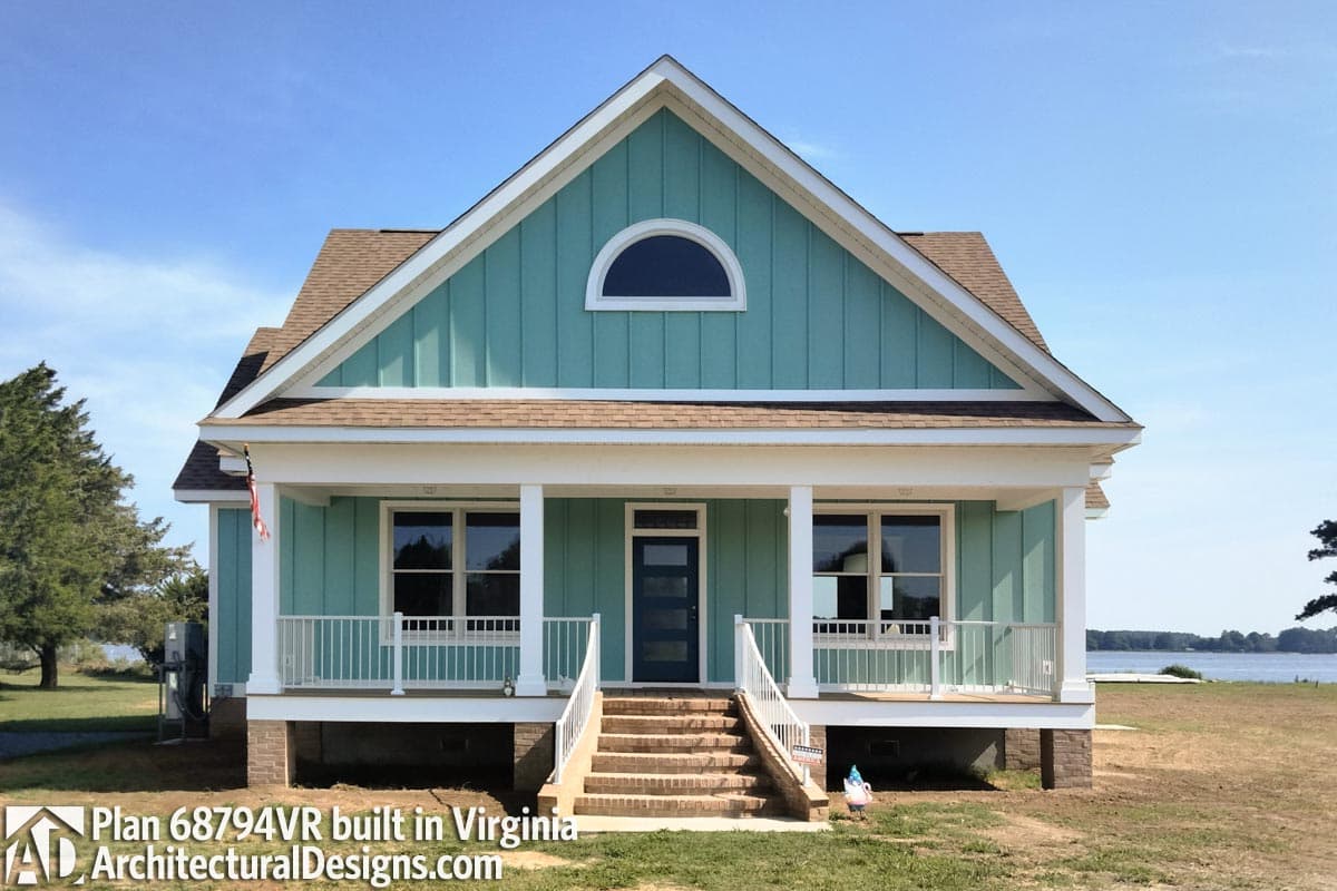 House plan exterior: One-story Modern Farmhouse with a covered front porch, vertical siding, and a prominent gable featuring a semicircular window.