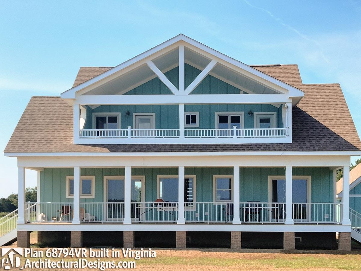 House plan exterior featuring a two-story design with wide porches, balconies, and a prominent gabled dormer with exposed rafters.
