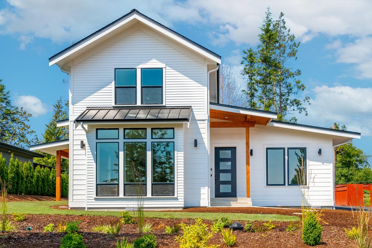 Modern farmhouse house plan exterior with two stories. Features include a gable roof, covered porch, and large windows.