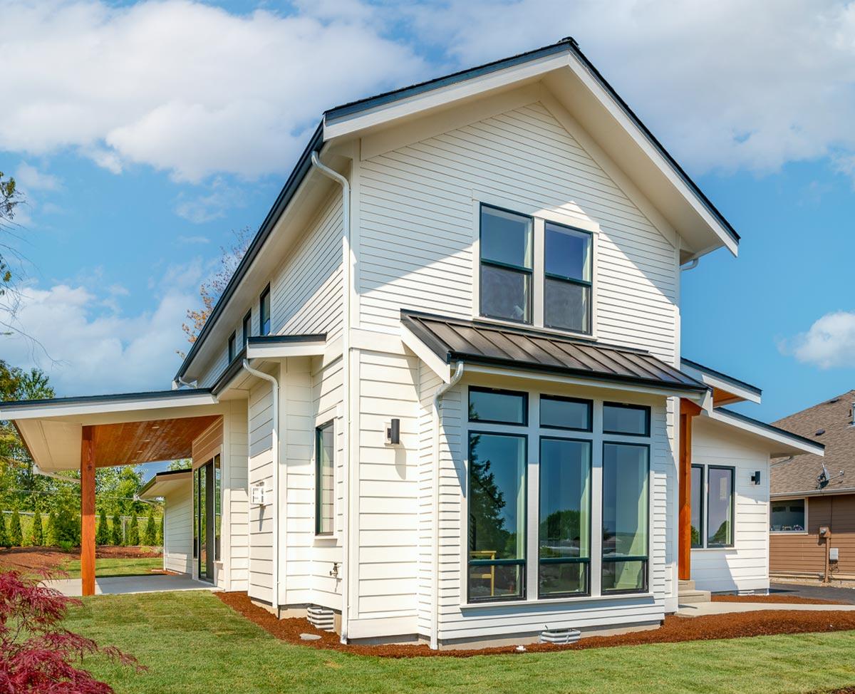 Modern Farmhouse style house plan exterior with white siding, gabled roof, covered porch, and large windows.