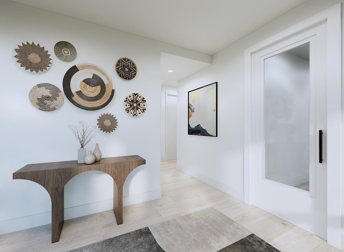 Interior view of a hallway with a console table, wall art, and a frosted glass door.