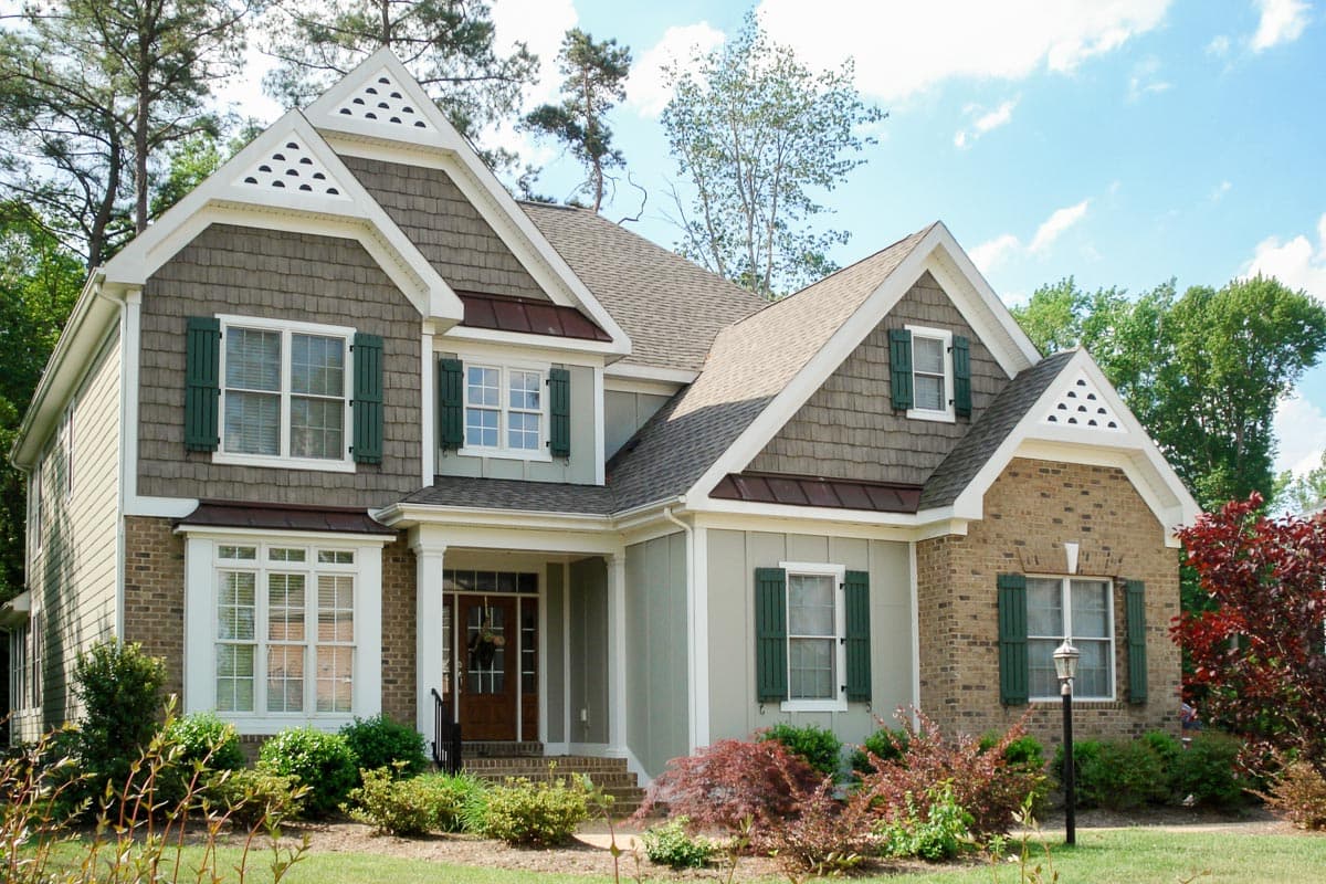 House plan exterior. Two-story home with Craftsman style. Features include multiple gables, shake siding, and a covered front porch.