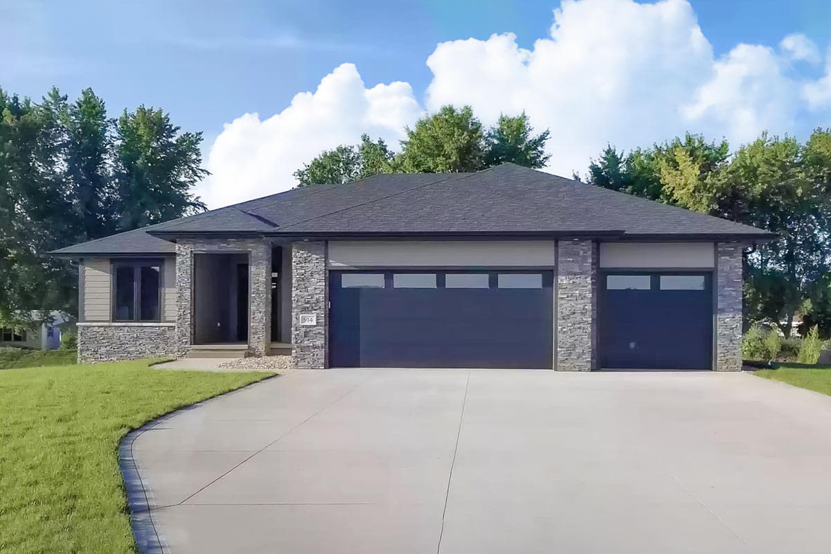 House plan exterior: single-story modern home with a three-car garage, stone accents, and covered entryway.