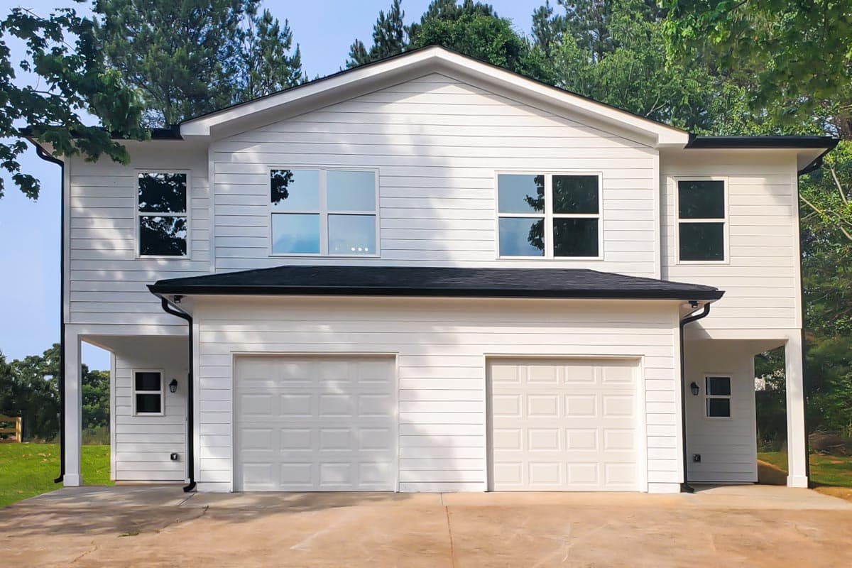 House plan exterior with two stories and a garage. Features include a gable roof, covered entryway, and horizontal siding.
