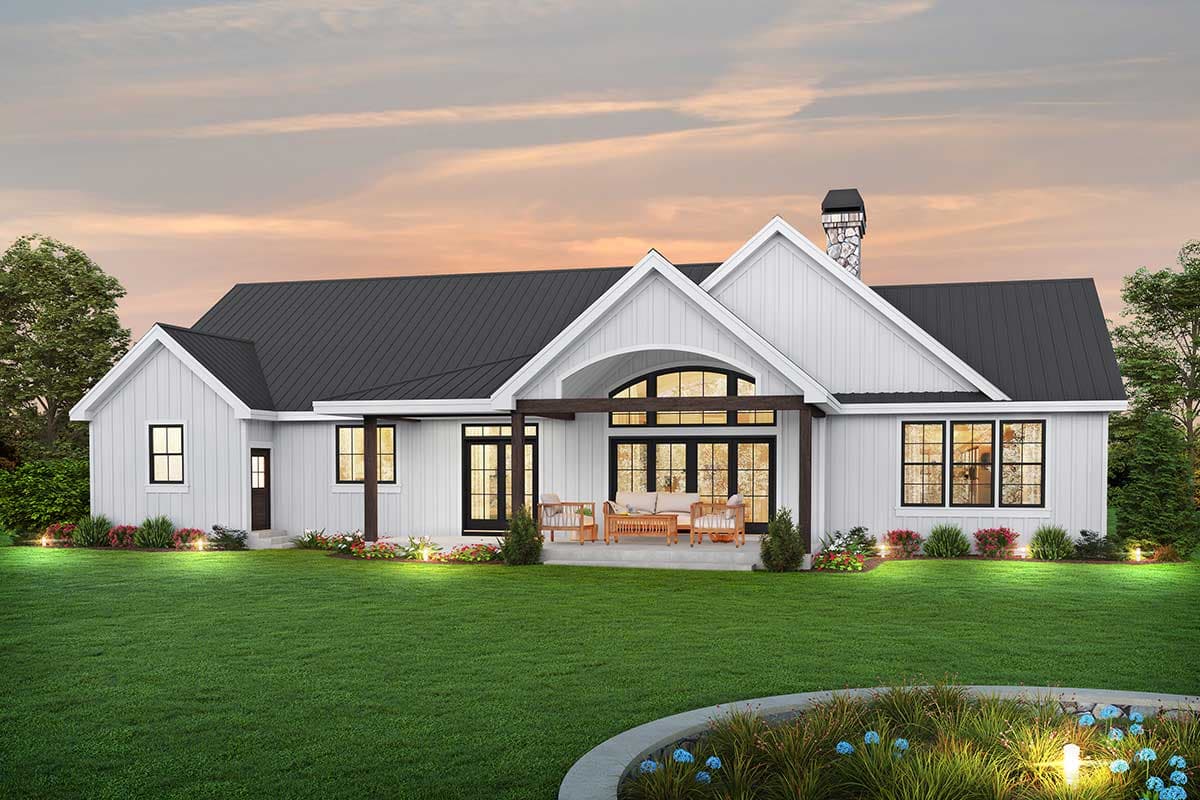 Modern Farmhouse house plan exterior with gables, stone chimney, metal roof, and covered patio with arched windows.