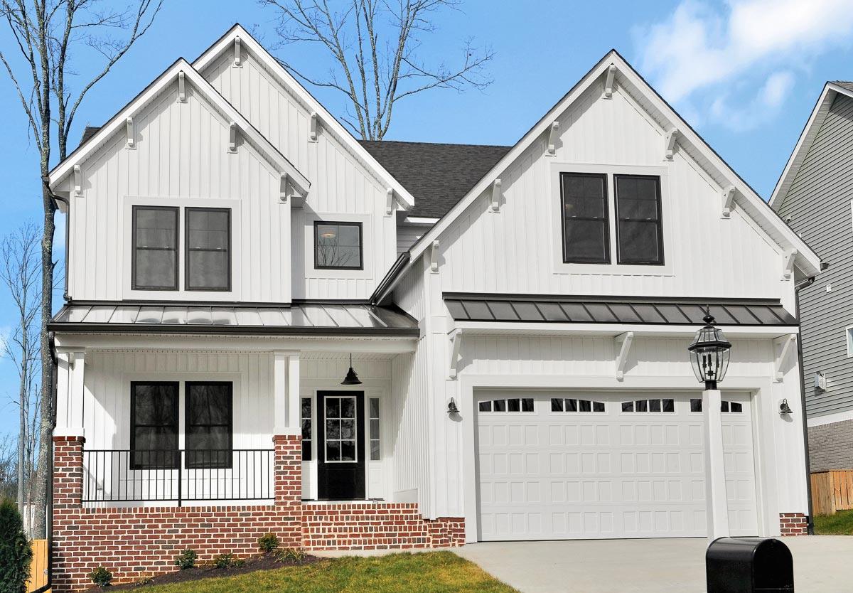 Modern Farmhouse house plan exterior with white board-and-batten siding, gables, porch, and a two-car garage.
