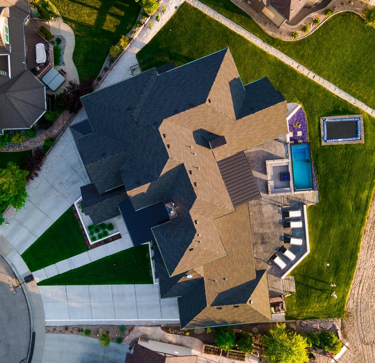 House plan exterior, showcasing complex rooflines, a multi-level deck, and an integrated pool and spa area.