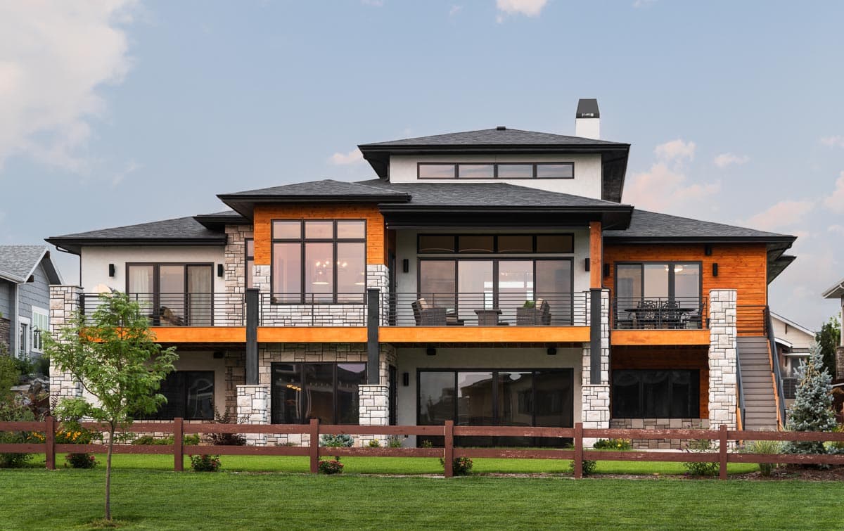 Modern house plan exterior with multiple levels, balconies, wood accents, stone detailing, and large windows.