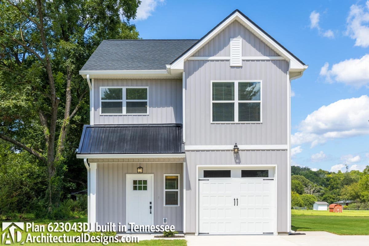 House plan exterior: two-story home with vertical siding, gabled dormer, metal roof awning, and attached garage.