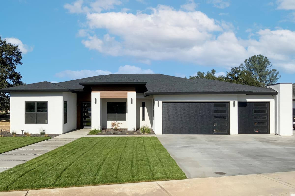 Modern single-story house plan exterior with white stucco, flat roof, wood accents, and a two-car garage with glass doors.