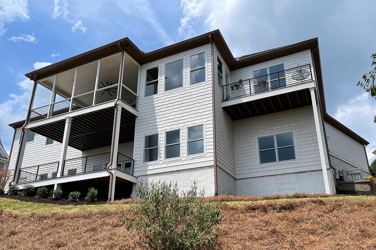 House plan exterior with screened porch, multiple balconies, and shingle siding.
