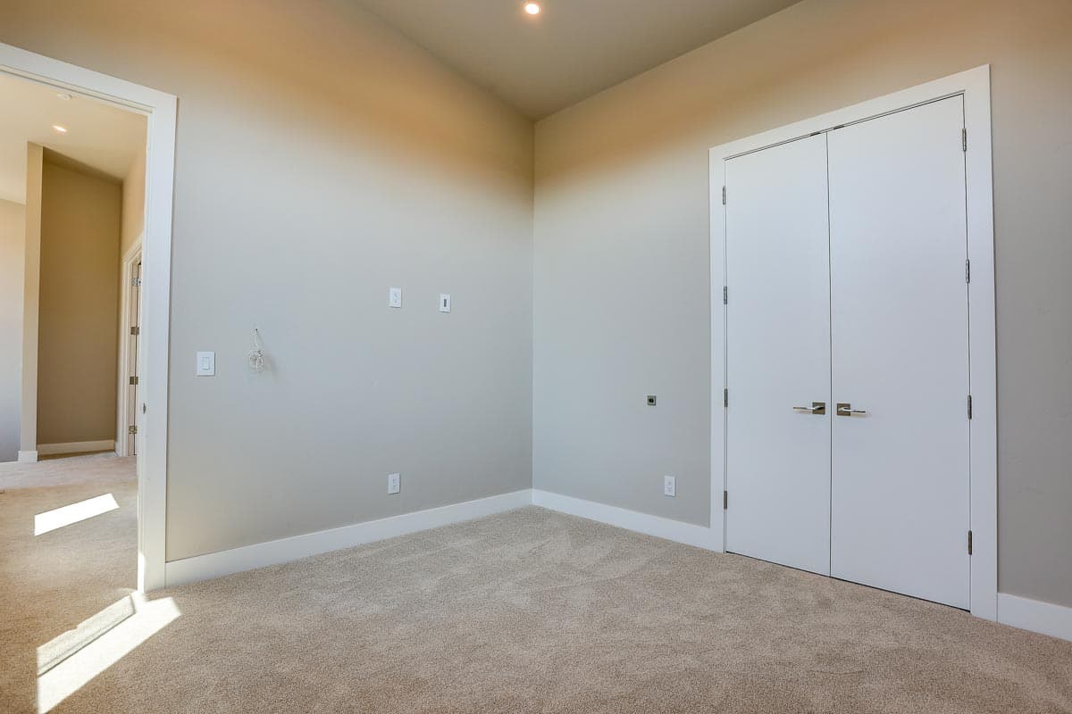 Interior view of a room with carpet, double doors, and an open doorway to another room.
