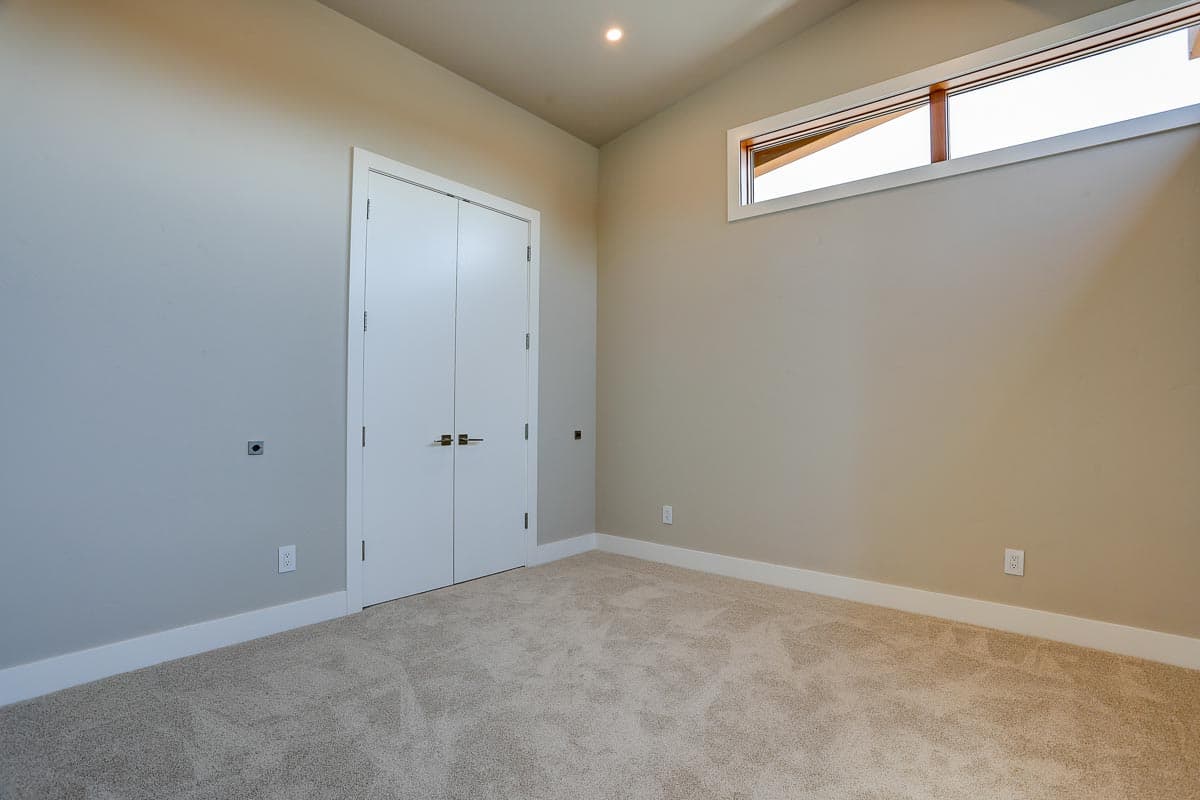 Interior view of room with double doors, carpet, and a horizontal clerestory window.