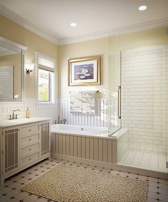 Bathroom with soaking tub, glass-enclosed shower with subway tile, vanity with drawers, and large framed mirror.