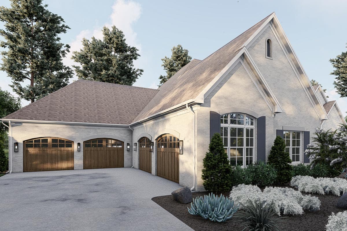 House plan exterior with white brick, multiple arched wood garage doors, and a prominent gable roofline.