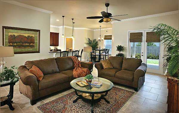 Open concept living area with a sectional sofa, glass coffee table, dining area, and kitchen with island.