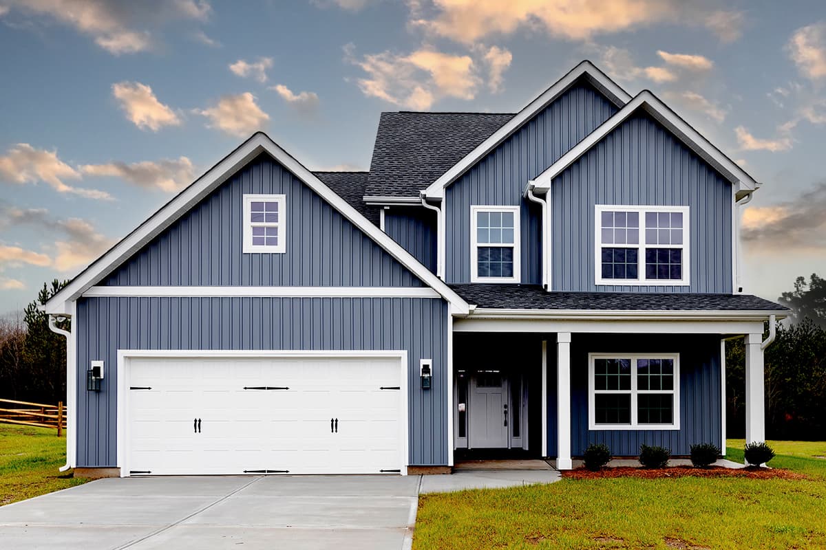 Modern Farmhouse style house plan exterior with blue vertical siding, two stories, white trim, a white garage door, and a covered front porch.