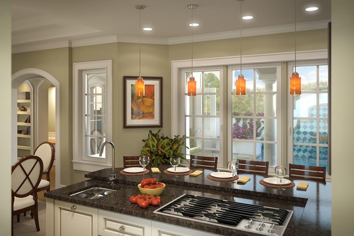 Kitchen island with granite countertop, sink, gas range, pendant lights, and view of arched doorway and windows.