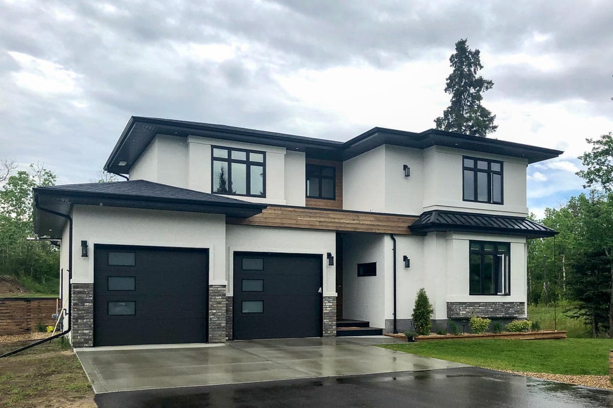 Modern two-story house plan exterior with stucco finish, double garage, intersecting rooflines, and horizontal wood accents.