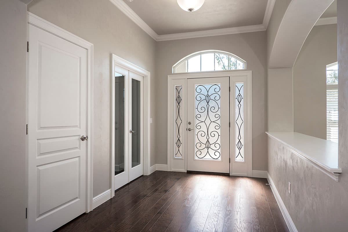 Entryway interior with double doors, arched sidelights, a plain door, and glass-paneled doors.