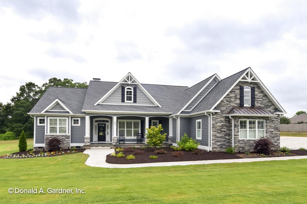 House plan exterior: Ranch-style, single-story home with covered front porch, stone accents, gables, and dormers.