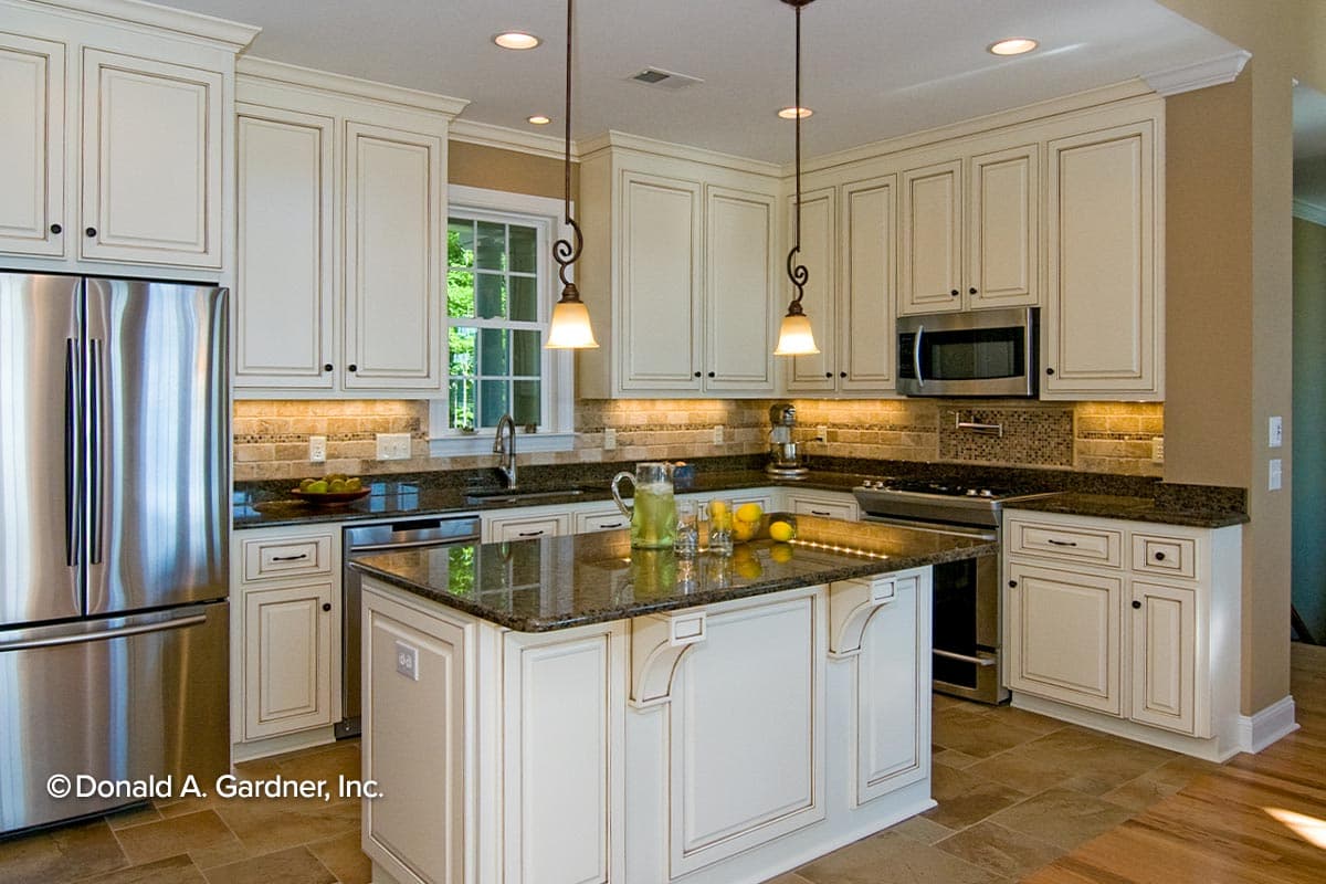 Kitchen with white cabinets, granite countertops, stainless steel appliances, and a central island.