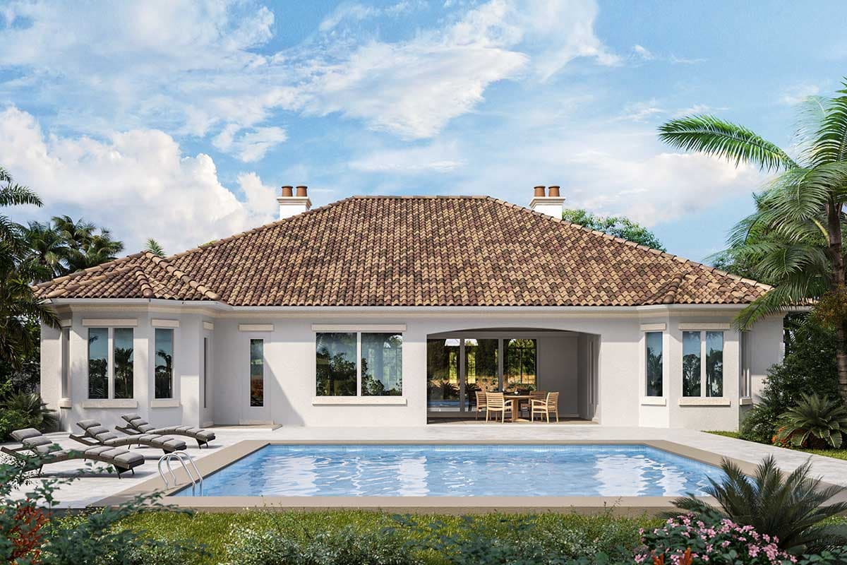 House plan exterior with a Mediterranean tile roof, two chimneys, large windows, and an outdoor dining area next to a swimming pool.