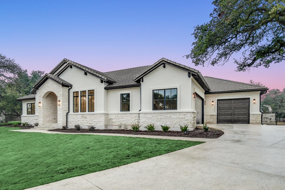House plan exterior: Modern design with stucco and stone facade, arched entryway, tiled roof, and attached garage.