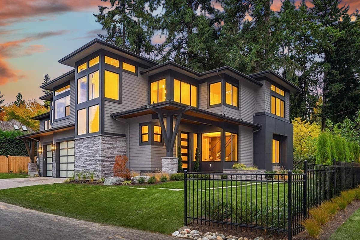 House plan exterior. Two-story modern home with stone veneer, flat roof, and covered entry. Features large windows and attached garage.