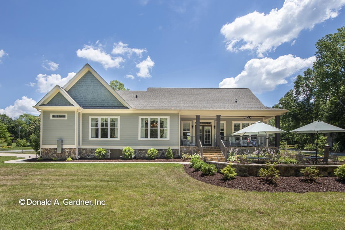 Craftsman-style house plan exterior, one story, with gabled dormers, stone foundation, and covered porch with columns.