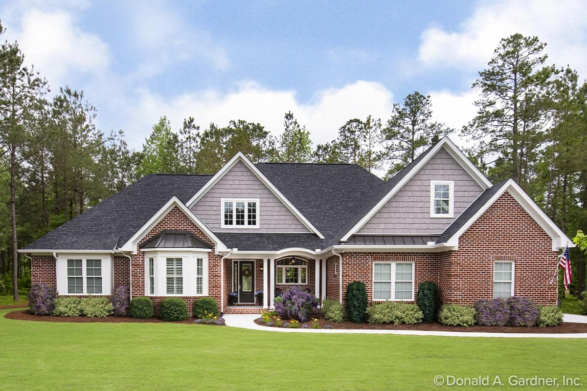 House plan exterior featuring a brick facade, multiple gables, a covered entry, and a multi-section roofline. Two-story structure.