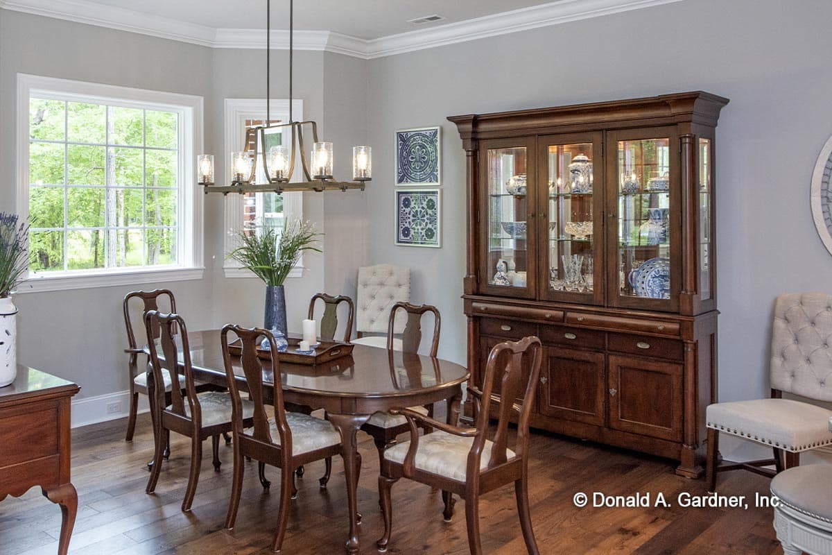 Dining room with oval table, six chairs, and a large wood china cabinet.