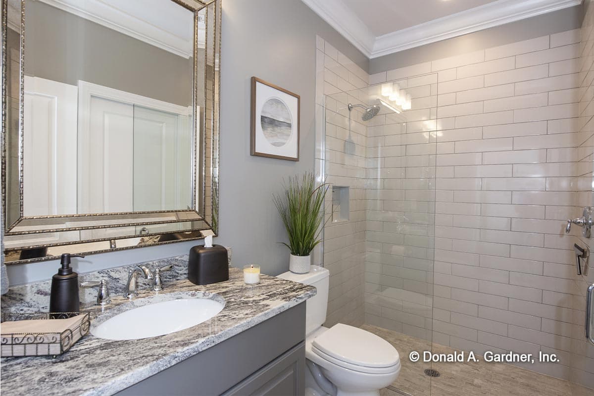 Bathroom with gray vanity, granite countertop, oval sink, large mirrored cabinet, and walk-in glass shower with white subway tile.
