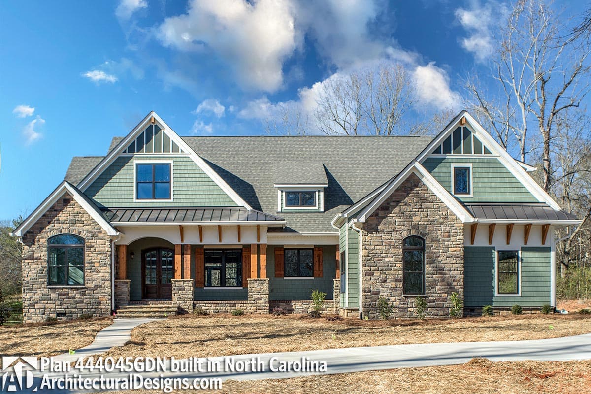 House plan exterior with stone and shingle siding, gables, dormers, and a covered front porch.