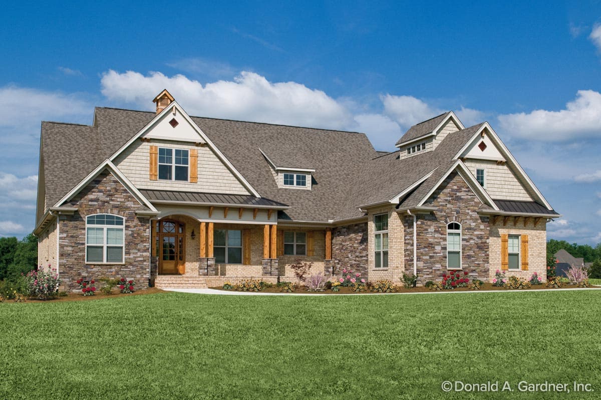 House plan exterior with stone and siding, multi-gabled roof, front porch with columns, and decorative shutters. One story house.