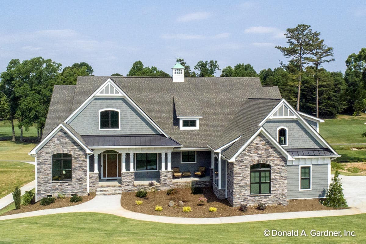 House plan exterior: One-and-a-half story, stone and shingle siding, multiple gables, covered front porch with columns, and dormer.