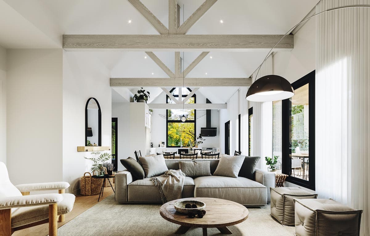 Great room with vaulted ceiling, exposed beams, large windows, sectional sofa, coffee table, and dining area.