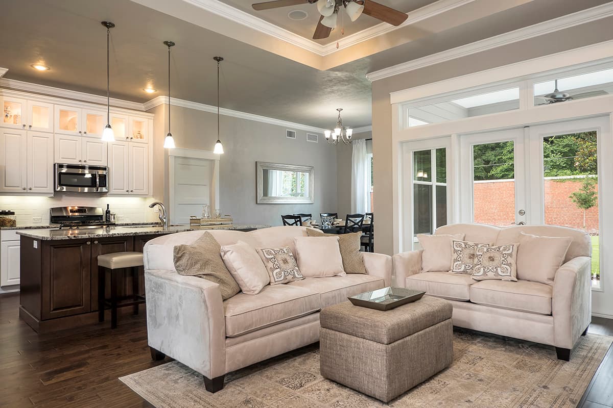 Open concept living area with kitchen island, seating area, and large glass doors.