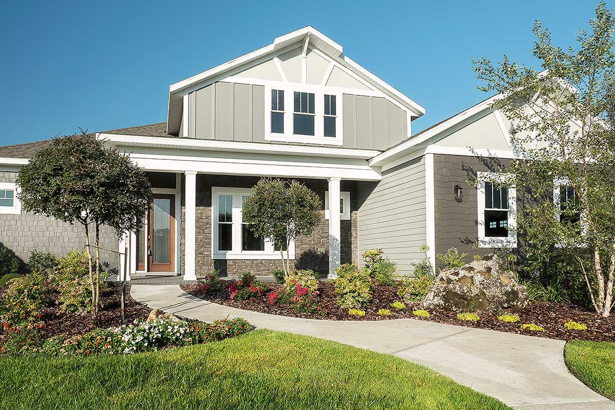 House plan exterior showing a two-story modern farmhouse with stone and horizontal siding, covered porch, and gabled dormer.