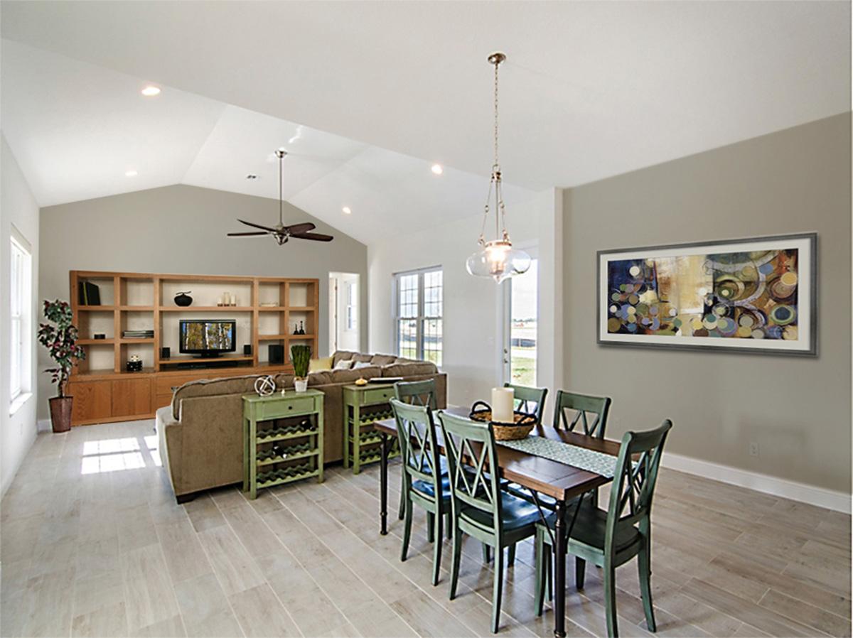 Open concept living and dining area with vaulted ceiling, entertainment center, and dining table.