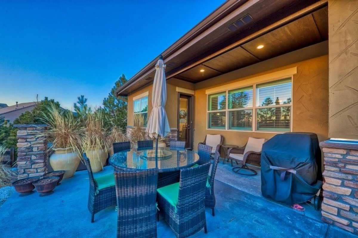 Covered patio with outdoor dining set, grill, and seating area.